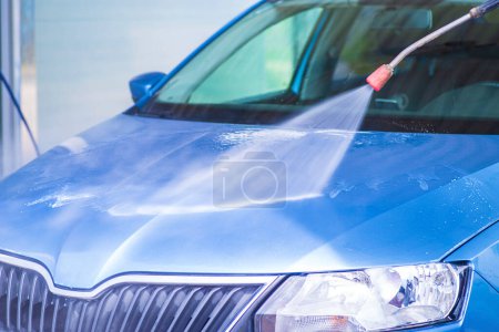 Photo for Manual car wash with pressurized water in car wash outside.Cleaning Car Using High Pressure Water - Royalty Free Image