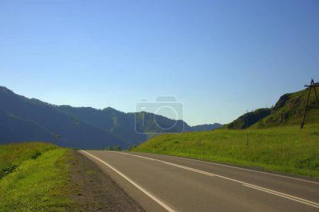 Téléchargez les photos : Une route asphaltée directe traverse la vallée de vol vers les chaînes de montagnes - en image libre de droit