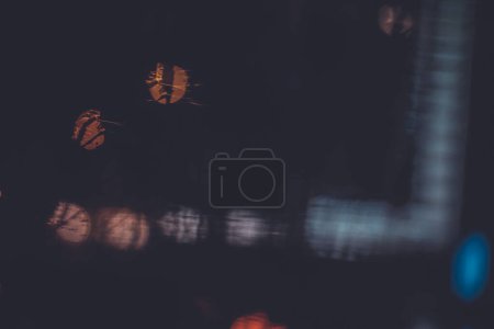 Téléchargez les photos : Feux de circulation à travers la fenêtre dans une nuit pluvieuse - en image libre de droit