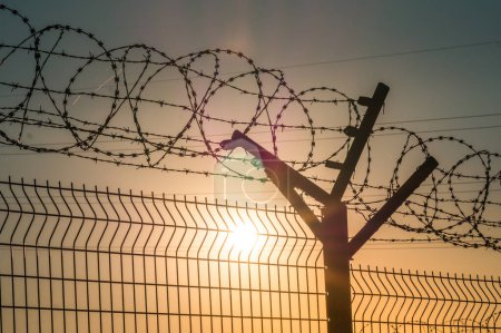 Téléchargez les photos : Barbelé clôture en acier contre l'immigration en Europe. Zone réglementée
. - en image libre de droit