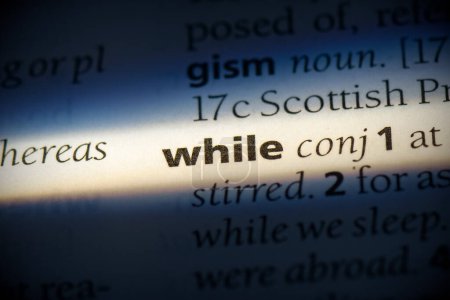 Foto de Mientras que la palabra, resaltado en el diccionario, vista de cerca - Imagen libre de derechos
