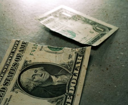 Photo for Torn Dollar currency on table - Royalty Free Image