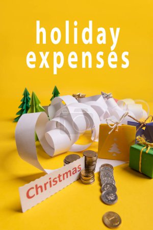 Photo for Holiday expenses concept. Long twisted christmas expenses list, presents, gifts, money coins and christmas text - Royalty Free Image