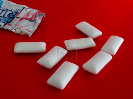 Photo for A lot of gum cubes slept on a red background. - Royalty Free Image