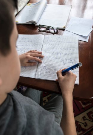 Téléchargez les photos : Enfant faisant ses devoirs - en image libre de droit