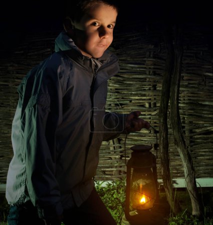 Téléchargez les photos : Enfant marche dans l'obscurité avec une lanterne - en image libre de droit