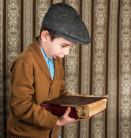 Téléchargez les photos : Gros plan de Child avec livre vintage rouge - en image libre de droit