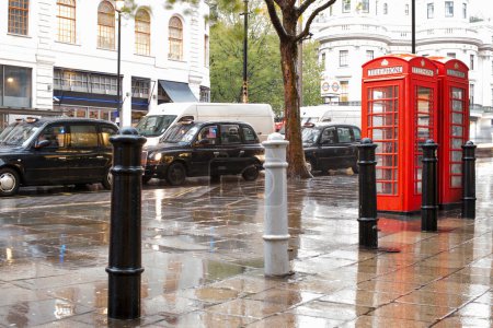 Foto de Cabinas Red Phone en Londres y taxi vintage. Día lluvioso. - Imagen libre de derechos