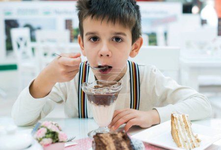 Téléchargez les photos : Enfant manger milk choco shake - en image libre de droit