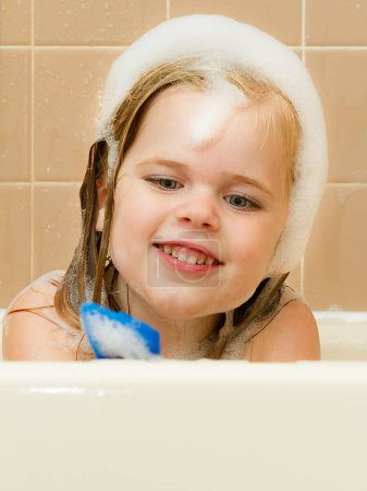Téléchargez les photos : Fille jouer avec un jouet dans la baignoire - en image libre de droit