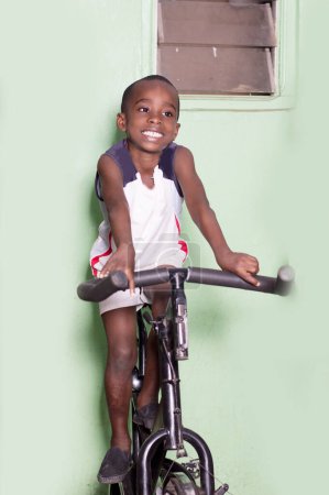 Téléchargez les photos : Petit garçon sur un vélo d'appartement dans la salle de gym. - en image libre de droit