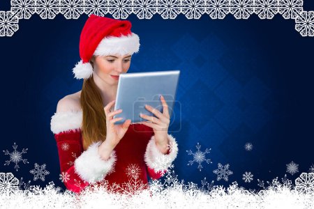 Téléchargez les photos : Image composite de jolie fille Santa en utilisant la tablette pc - en image libre de droit