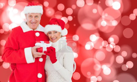 Téléchargez les photos : "Image composite de couple mature festif tenant cadeau
" - en image libre de droit