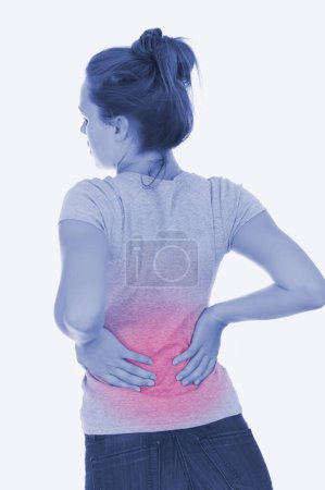 Foto de Mujer joven que sufre de dolor de espalda - Imagen libre de derechos