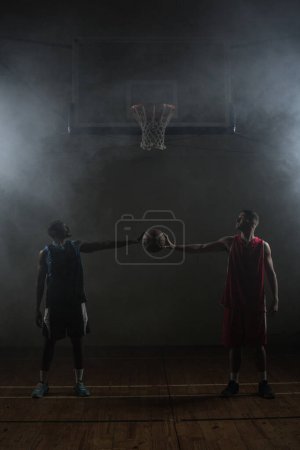 Foto de Dos jugadores de baloncesto sosteniendo un solo baloncesto - Imagen libre de derechos