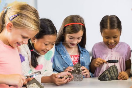 Foto de Grupo de niños mirando la piedra del espécimen a través de la lupa - Imagen libre de derechos
