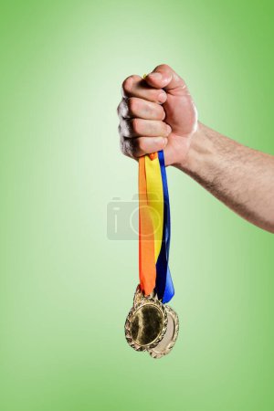 Photo for Composite image of hand holding two olympic gold medals - Royalty Free Image