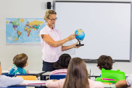 Téléchargez les photos : Enseignant ayant une leçon avec un globe - en image libre de droit