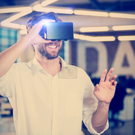 Téléchargez les photos : Sourire Homme d'affaires portant un simulateur de réalité virtuelle - en image libre de droit