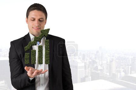 Photo for Businessman holding a graph plant - Royalty Free Image