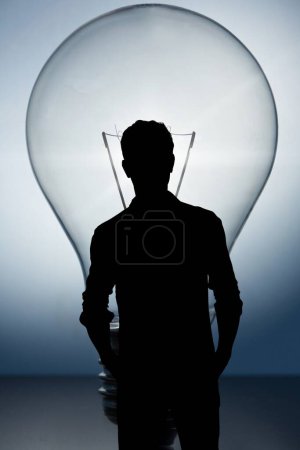 Téléchargez les photos : Homme debout devant une ampoule - en image libre de droit