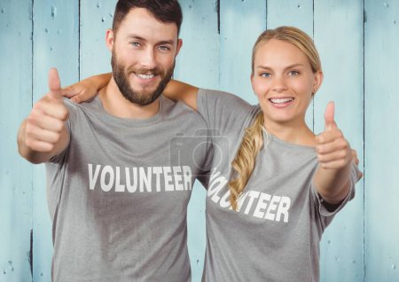 Photo for "Couple of volunteer thumbs up against wooden blue background" - Royalty Free Image
