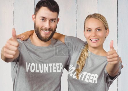 Téléchargez les photos : Couple de bénévoles souriants pouce vers le haut sur fond en bois - en image libre de droit