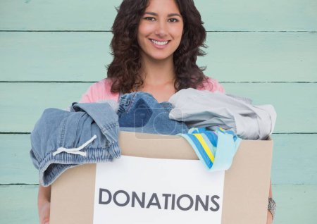 Photo for Young hispanic woman holding cardboard for donation clothes with happy face - Royalty Free Image