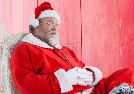 Téléchargez les photos : Père Noël endormi sur fond de bois rouge - en image libre de droit