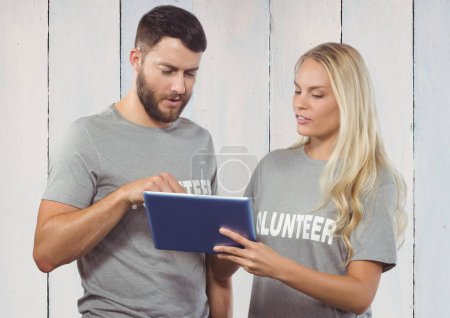 Photo for "Working couple of volunteer against wooden background" - Royalty Free Image