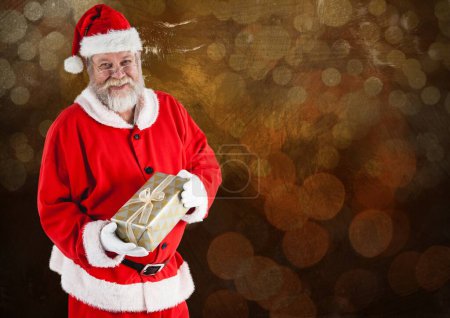 Téléchargez les photos : Père Noël tenant cadeau sur fond flou - en image libre de droit