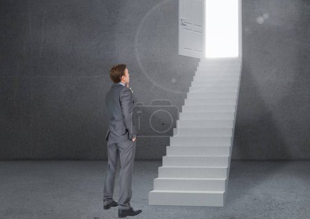 Photo for Pensive businessman looking at stairs against grey background - Royalty Free Image