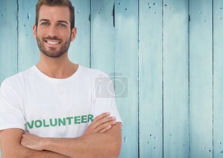 Foto de Voluntario sonriente contra fondo de madera azul - Imagen libre de derechos