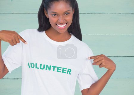 Téléchargez les photos : Volontaire femme souriant sur fond en bois - en image libre de droit