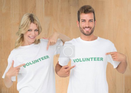Téléchargez les photos : Composite numérique de bénévoles pointant vers leurs chemises - en image libre de droit