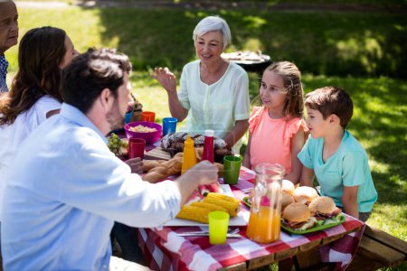 Téléchargez les photos : Heureuse famille multi-génération prenant le repas sur la table - en image libre de droit