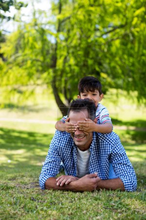 Photo for Boy covering his fathers eyes in park - Royalty Free Image