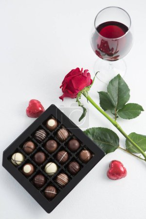 Photo for Chocolate box, roses and red wine glass on white background - Royalty Free Image