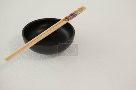 Photo for Pair of chopsticks for asian food on white tabletop - Royalty Free Image