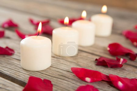 Téléchargez les photos : Bougies ardentes entourées de pétales de rose aromatiques - en image libre de droit