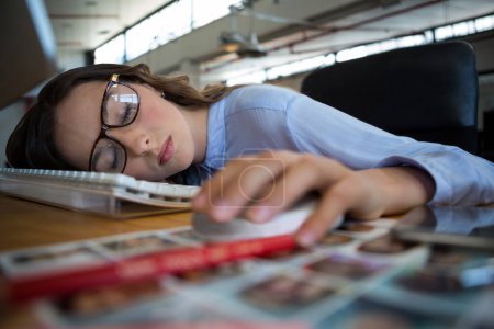 Téléchargez les photos : Graphiste féminine dormant au bureau - en image libre de droit