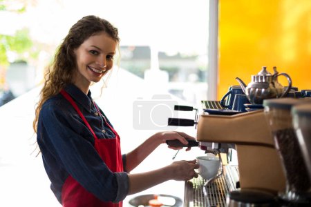 Photo for Smiling waitress making cup of coffee - Royalty Free Image