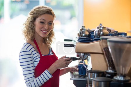 Photo for Portrait of smiling waitress making cup of coffee - Royalty Free Image
