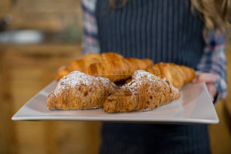 Téléchargez les photos : Serveuse tenant un plateau de petit déjeuner dans un café - en image libre de droit