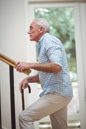 Téléchargez les photos : Senior homme monter les escaliers avec bâton de marche - en image libre de droit