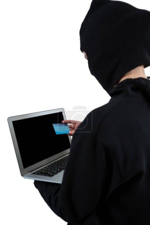Téléchargez les photos : Pirate utilisant un ordinateur portable et carte de crédit - en image libre de droit