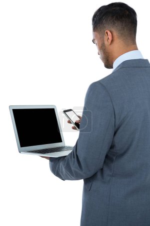 Téléchargez les photos : Homme d'affaires utilisant un ordinateur portable et un téléphone mobile - en image libre de droit