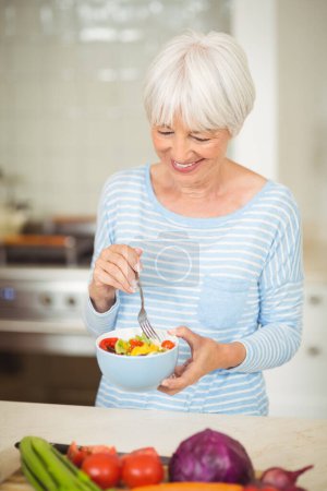 Téléchargez les photos : Heureuse femme âgée tenant bol de salade de légumes - en image libre de droit