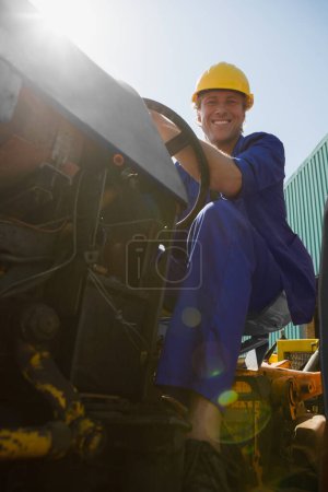 Téléchargez les photos : Portrait d'un travailleur souriant conduisant un tracteur - en image libre de droit