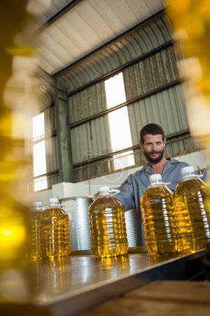 Téléchargez les photos : Travailleur debout avec boîte d'huile d'olive dans l'usine - en image libre de droit